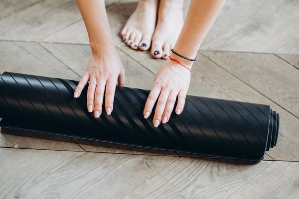 Woman performing a gentle stretching exercise on a yoga mat.